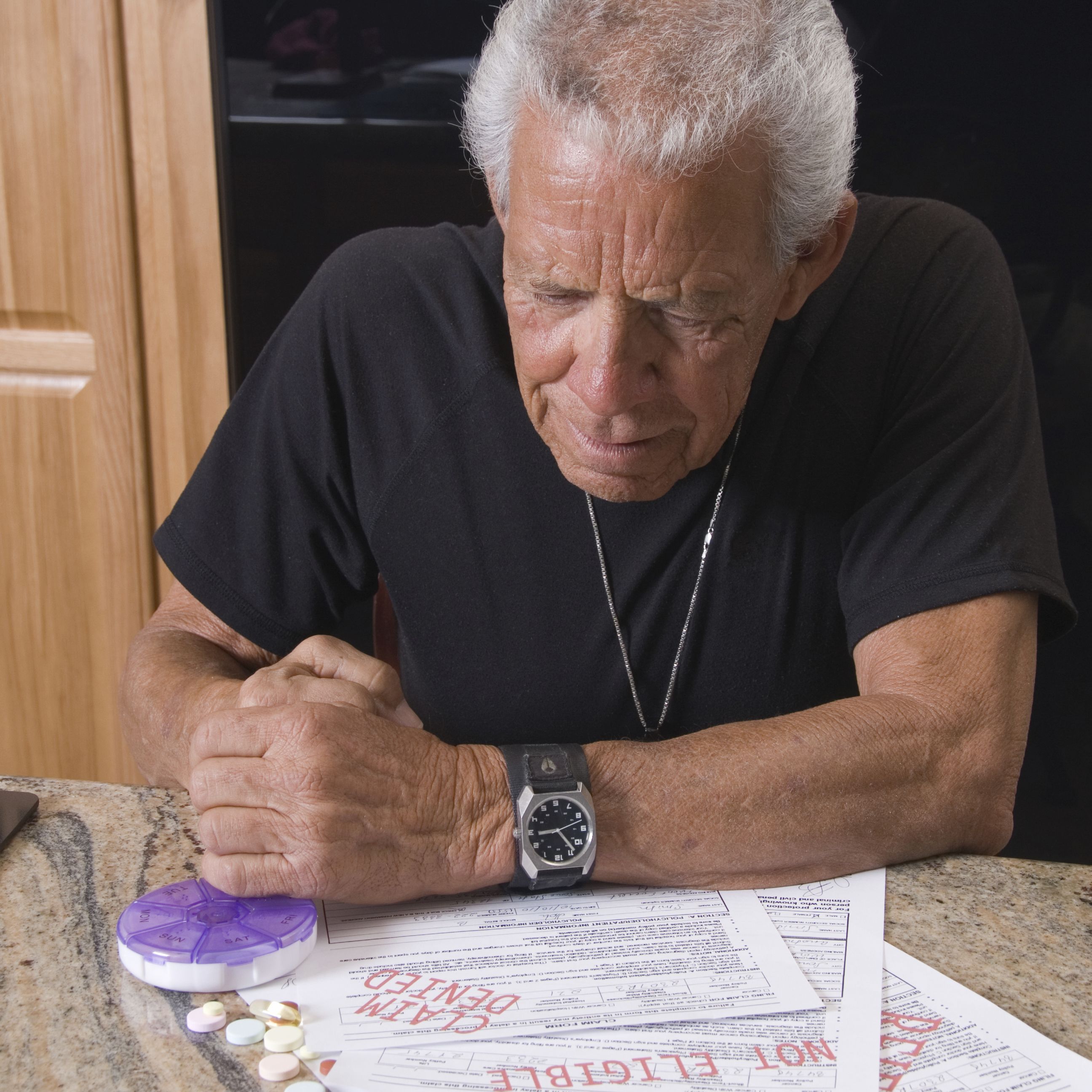 Photo of an older man looking at insurance paperwork
