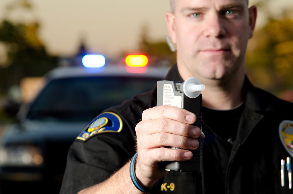 Policeman holding breathalyzer