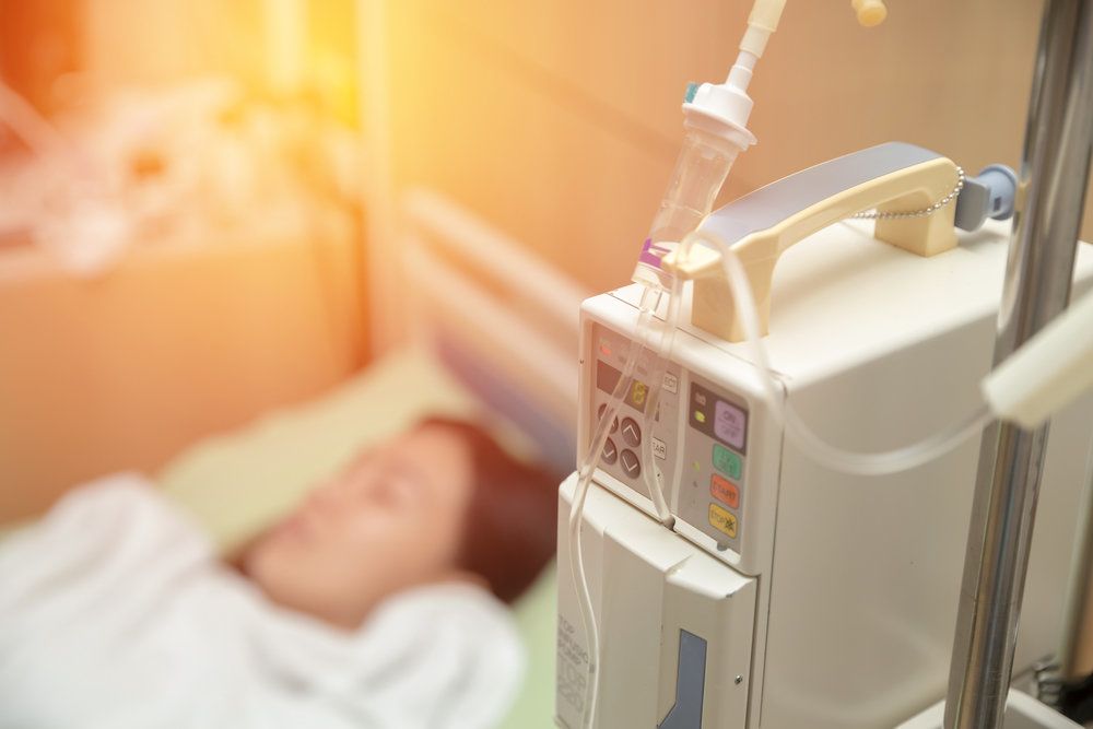 Blurred woman lying in hospital bed and receiving IV